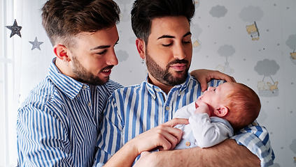 Two fathers holding their newborn baby