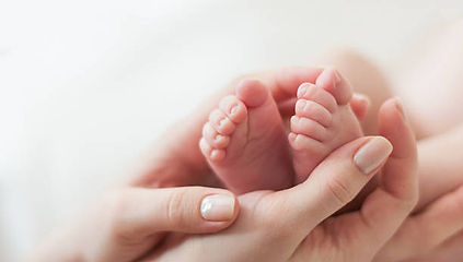 Newborn baby's feet held in a parent's hands