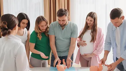 Midwifery students practicing birth skills on a training mannequin