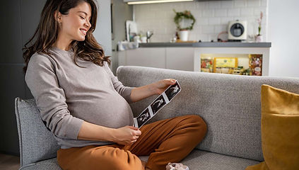 Pregnant woman looking at an ultrasound image at home